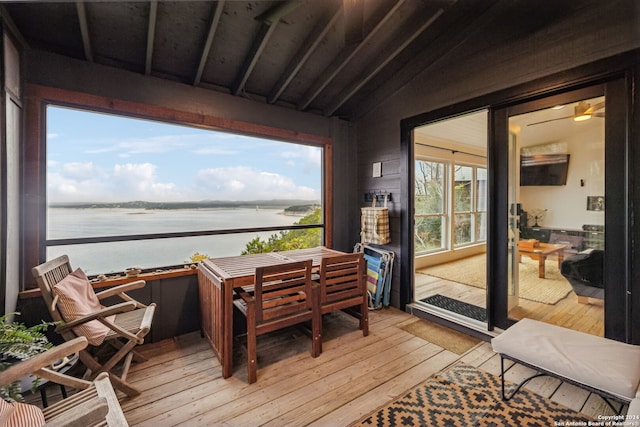 sunroom / solarium with lofted ceiling and a water view