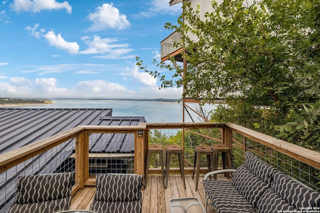 wooden deck featuring a water view and outdoor lounge area