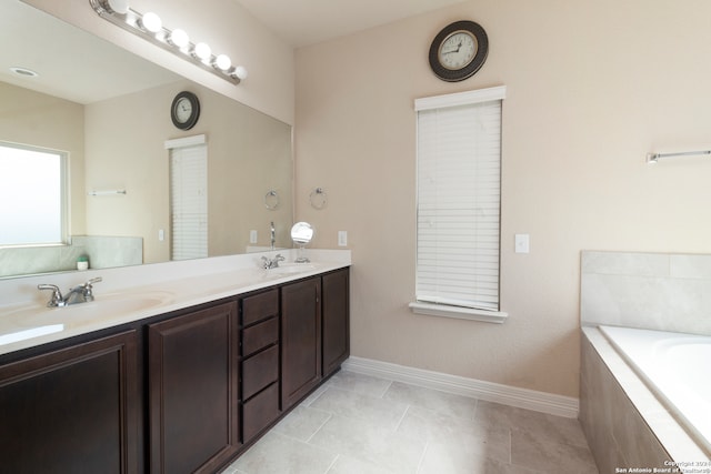 bathroom with vanity, a relaxing tiled tub, and tile patterned floors