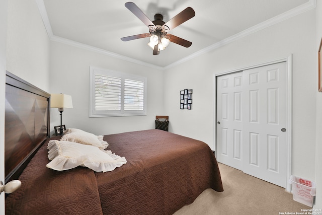 carpeted bedroom featuring ornamental molding, a closet, and ceiling fan