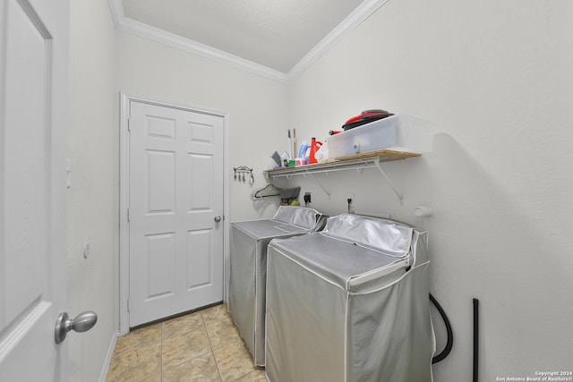 laundry room featuring ornamental molding, washing machine and dryer, and light tile patterned floors