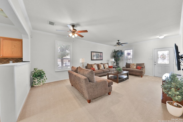 carpeted living room featuring crown molding and ceiling fan