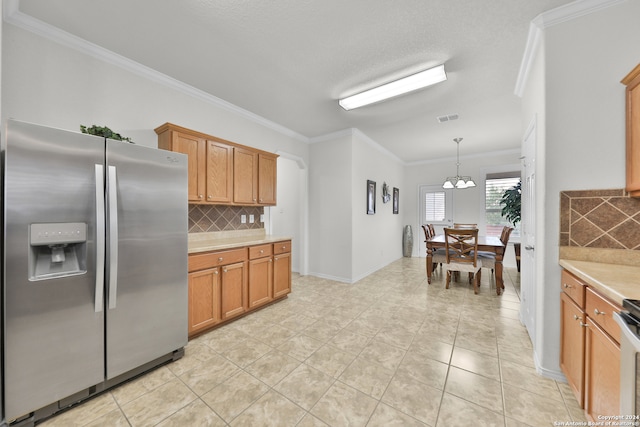 kitchen featuring decorative backsplash, crown molding, stainless steel refrigerator with ice dispenser, and decorative light fixtures