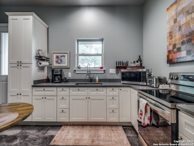 kitchen with sink, white cabinets, and stainless steel appliances