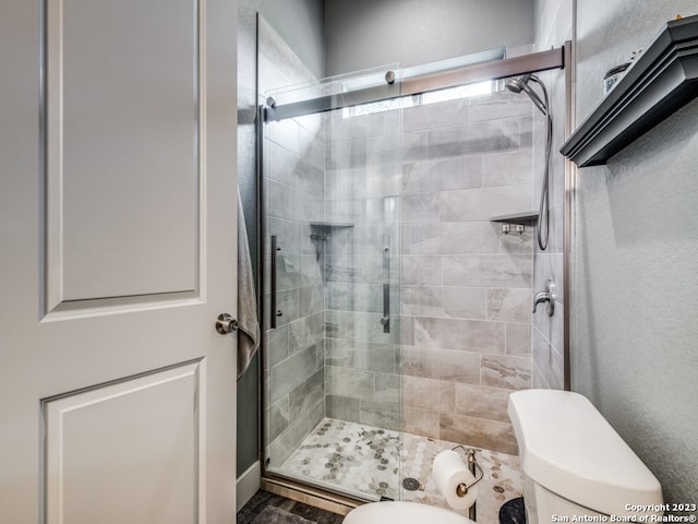 bathroom with toilet, hardwood / wood-style flooring, and a shower with shower door