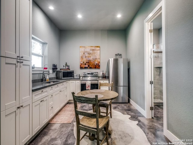 338 Salt Grass Trl, Bandera, TX 78003 - kitchen featuring stainless steel appliances, a sink, recessed lighting, baseboards, and dark countertops