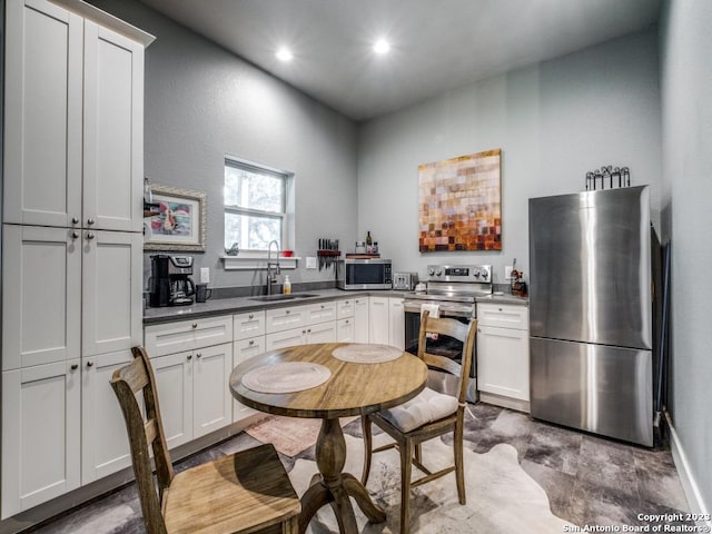 338 Salt Grass Trl, Bandera, TX 78003 - kitchen with stainless steel appliances, a sink, recessed lighting, dark countertops, and white cabinetry