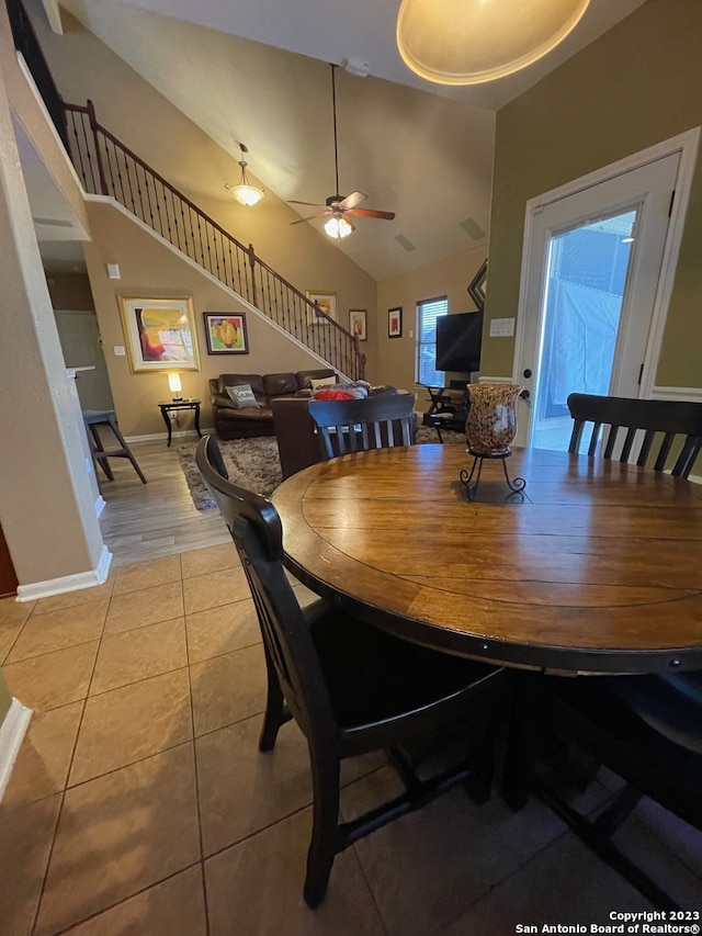 dining space featuring ceiling fan, high vaulted ceiling, and light tile patterned floors