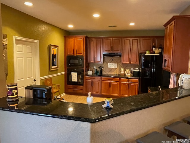 kitchen with black appliances, dark stone counters, kitchen peninsula, and decorative backsplash