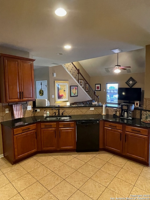 kitchen with black dishwasher, sink, kitchen peninsula, ceiling fan, and dark stone counters