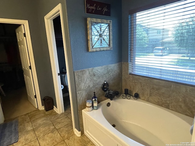 bathroom featuring a bathing tub, a healthy amount of sunlight, and tile patterned flooring