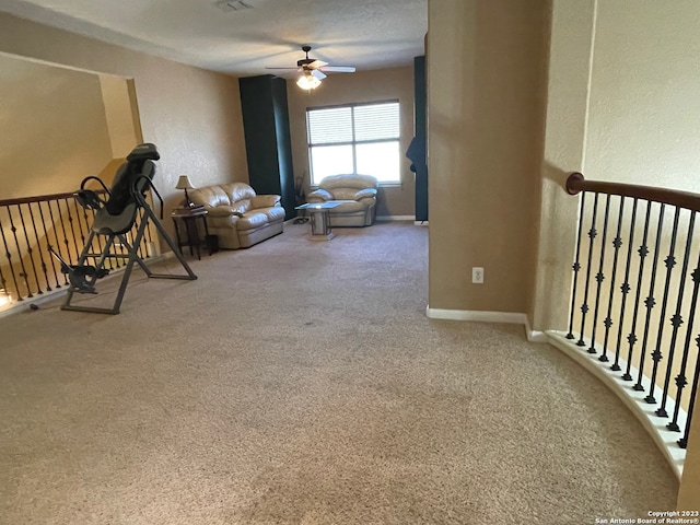 living room with ceiling fan, carpet flooring, and a textured ceiling