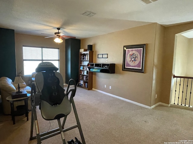 interior space featuring carpet, a textured ceiling, and ceiling fan