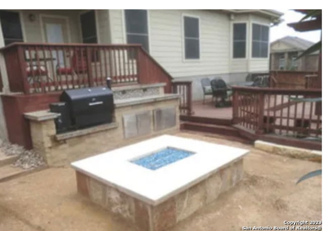 exterior space with a fire pit and a grill