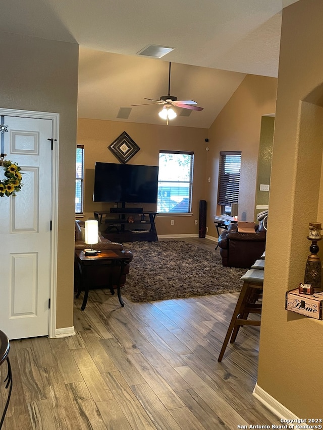 living room featuring hardwood / wood-style floors, vaulted ceiling, and ceiling fan