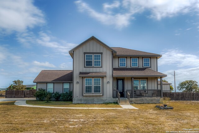 view of front facade featuring covered porch and a front lawn