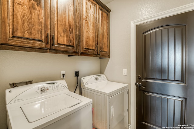 washroom featuring cabinets and washer and clothes dryer