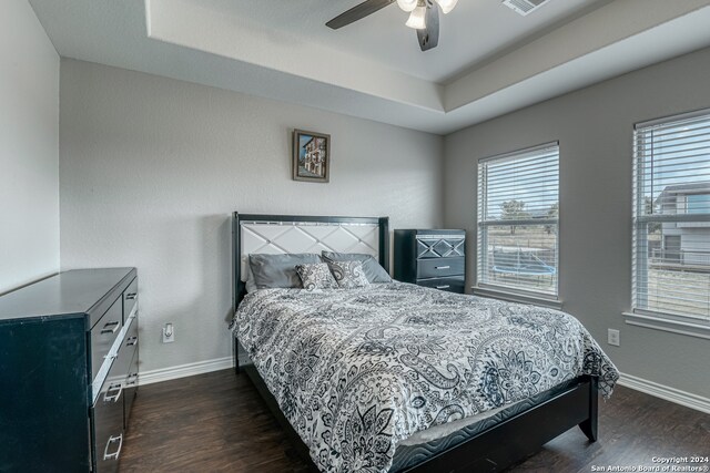 bedroom with multiple windows, dark hardwood / wood-style floors, and ceiling fan