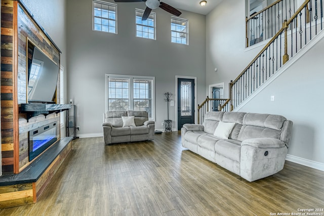 living room featuring hardwood / wood-style flooring, a towering ceiling, and ceiling fan