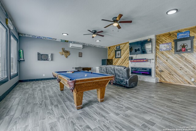 game room featuring hardwood / wood-style flooring, wood walls, a wall mounted AC, and billiards