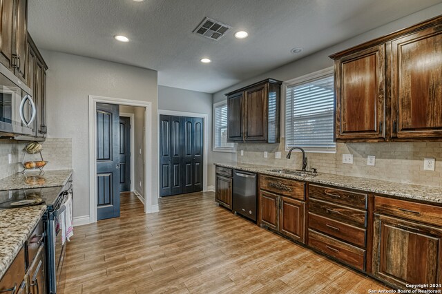 kitchen featuring light hardwood / wood-style flooring, sink, light stone counters, and stainless steel appliances