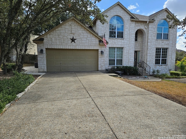 view of front of property with central air condition unit and a garage