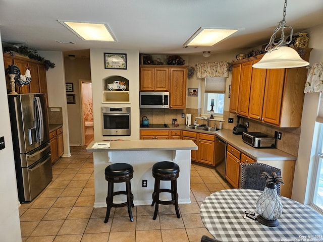 kitchen with stainless steel appliances, a center island, decorative light fixtures, light tile patterned floors, and tasteful backsplash