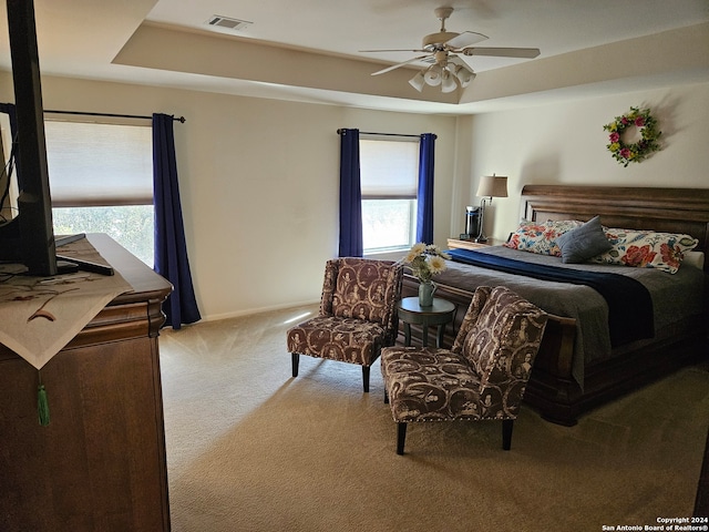 carpeted bedroom with multiple windows and ceiling fan