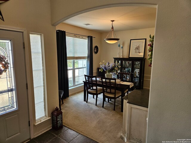 dining space featuring dark carpet