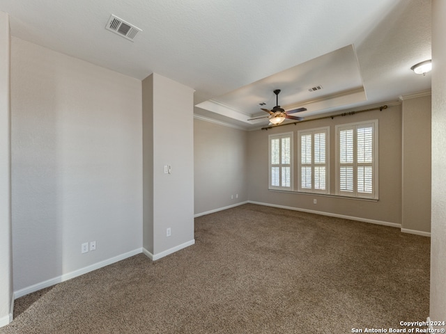 carpeted spare room featuring ornamental molding, ceiling fan, and a tray ceiling