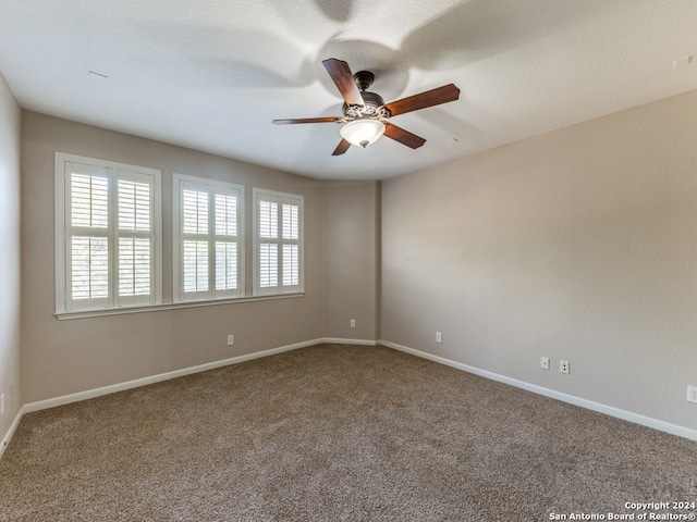 empty room featuring carpet, a wealth of natural light, and ceiling fan