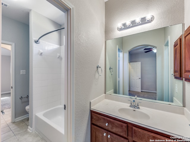 full bathroom featuring vanity, tile patterned flooring, tiled shower / bath combo, and toilet