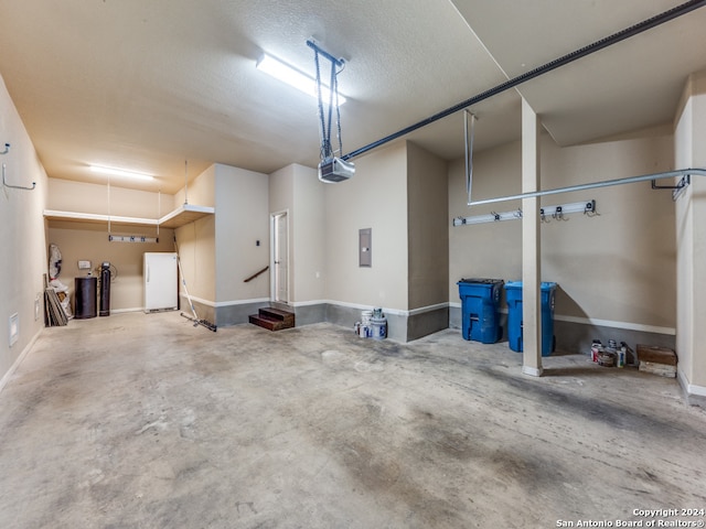 garage featuring white refrigerator, a garage door opener, and electric panel