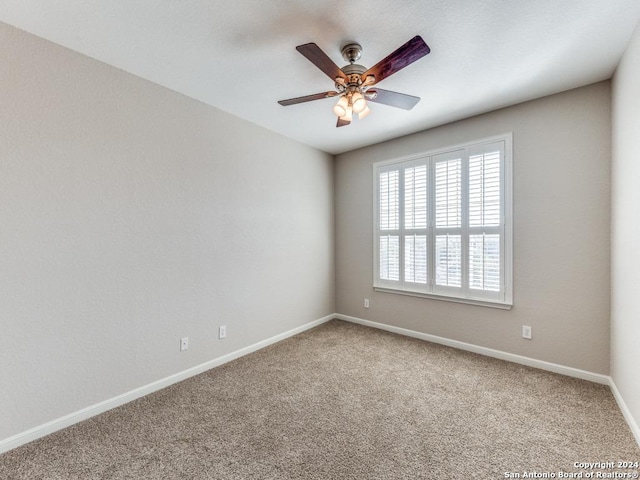 carpeted spare room with ceiling fan