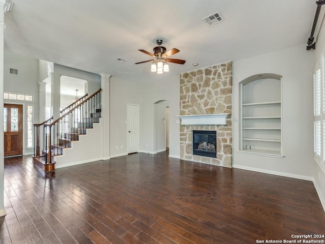 819 Tiger Lily, San Antonio, TX 78260 - unfurnished living room with a ceiling fan, built in shelves, a stone fireplace, wood finished floors, and baseboards