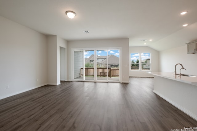 unfurnished living room with lofted ceiling, sink, and dark hardwood / wood-style flooring