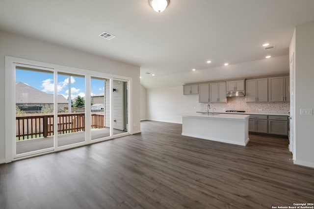 kitchen featuring dark wood-type flooring, gray cabinetry, and a center island with sink