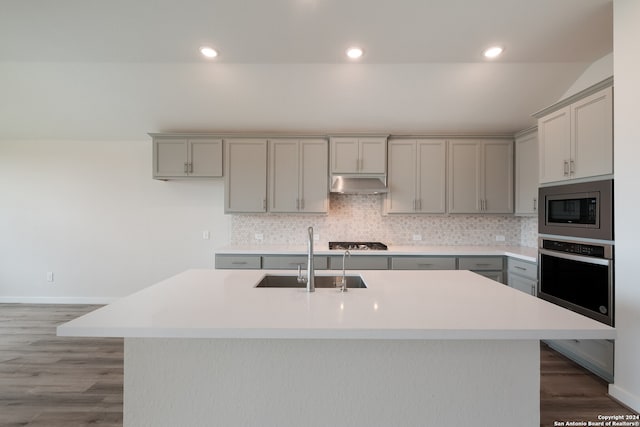 kitchen with appliances with stainless steel finishes, sink, an island with sink, and gray cabinets