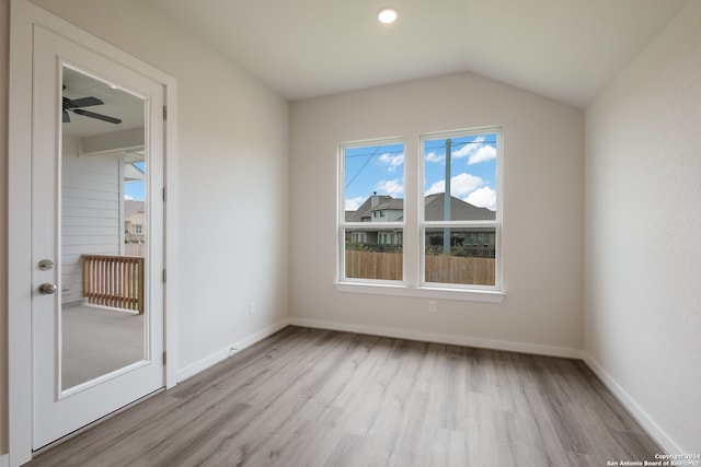 empty room featuring vaulted ceiling, light hardwood / wood-style floors, and ceiling fan