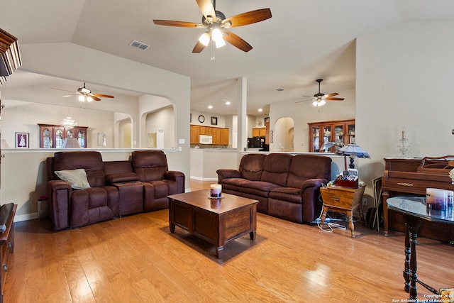 living room featuring ceiling fan, lofted ceiling, and light hardwood / wood-style flooring