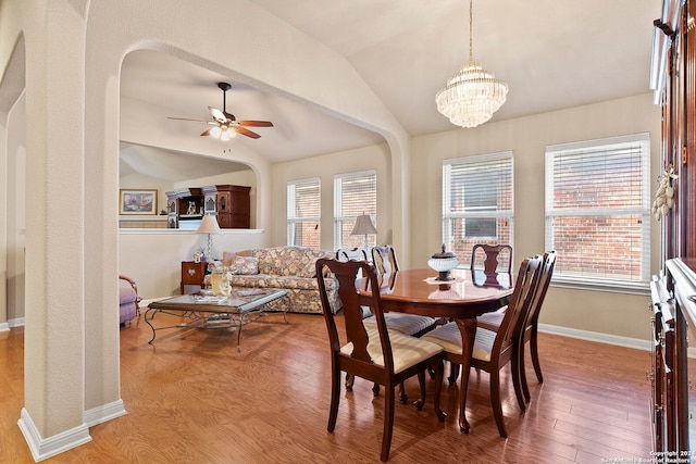 dining room featuring lofted ceiling, hardwood / wood-style flooring, and ceiling fan with notable chandelier