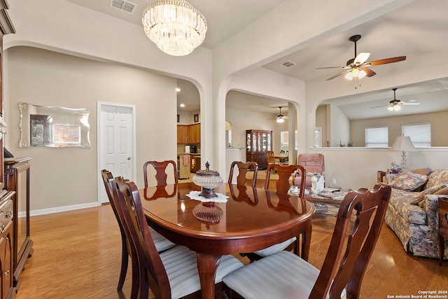 dining space featuring light hardwood / wood-style flooring and ceiling fan with notable chandelier