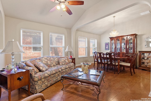 living room featuring lofted ceiling, hardwood / wood-style floors, ceiling fan with notable chandelier, and a wealth of natural light