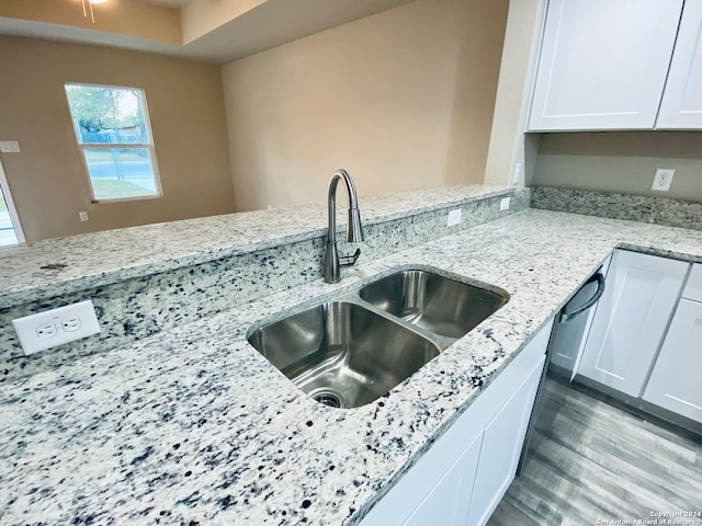 kitchen featuring white cabinetry, sink, and light stone counters