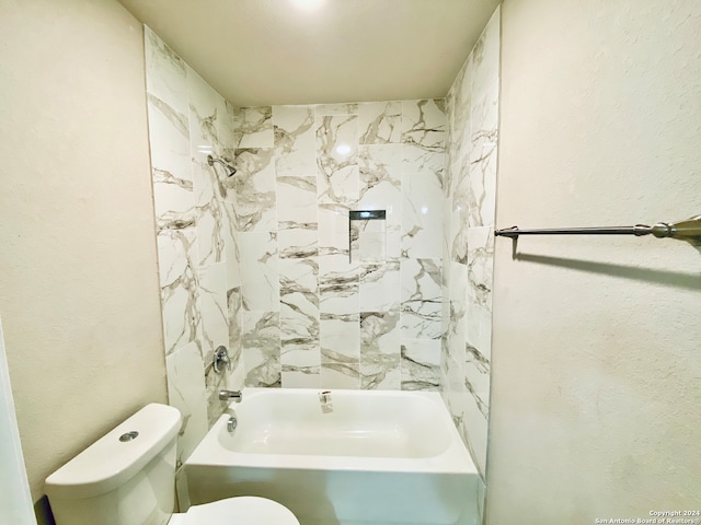 bathroom featuring tiled shower / bath and toilet