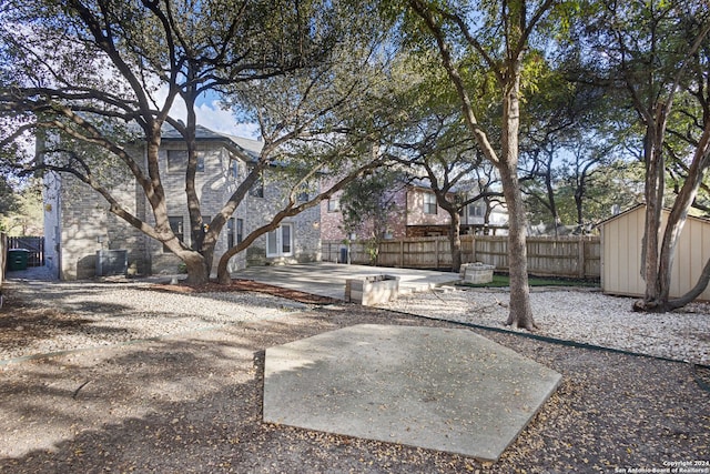 view of yard featuring a patio and a storage unit