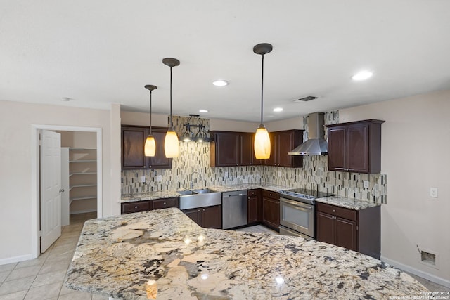 kitchen with wall chimney range hood, appliances with stainless steel finishes, sink, backsplash, and pendant lighting