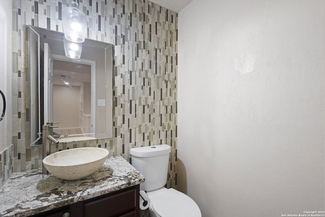 bathroom with tile walls, vanity, and toilet