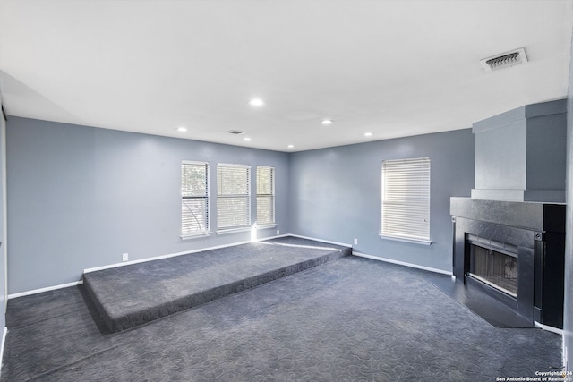 unfurnished living room featuring dark colored carpet