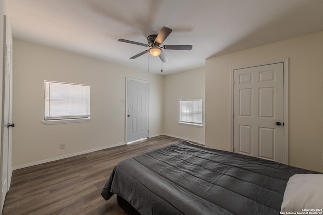 bedroom with dark hardwood / wood-style floors and ceiling fan